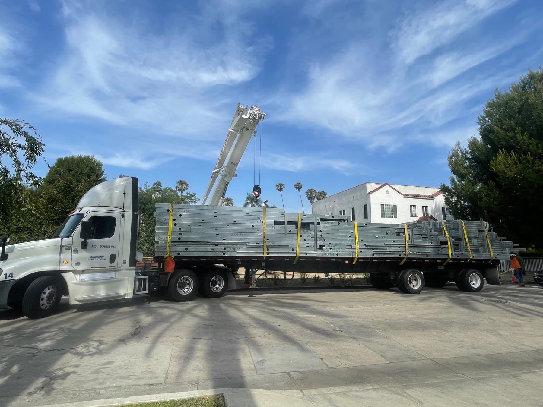 Factory-built flat light-gauge steel wall panels delivered by flatbed to the build site