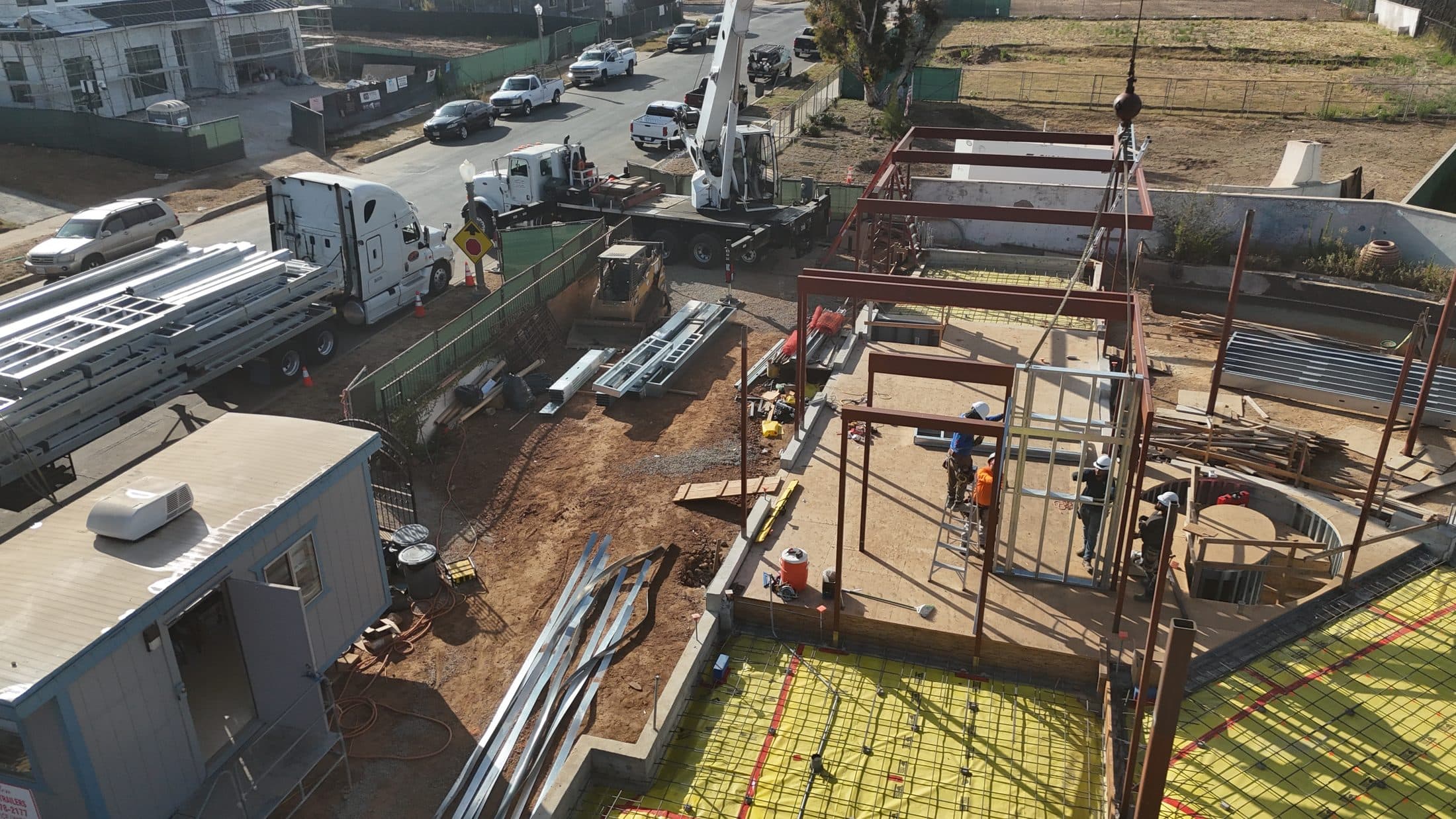 Aerial close-in of the structural steel frame and crew at 777 Ocampo Drive, Pacific Palisades